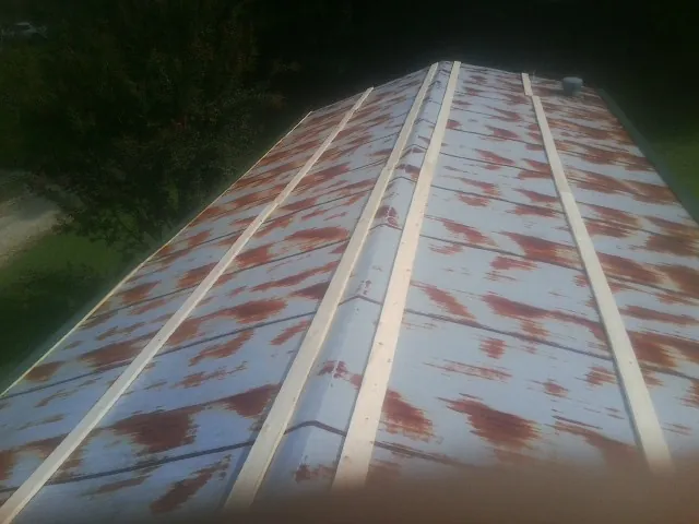 Rusted metal roof panels with new wood purlins before replacement — Storm Damage Roof Repair in Hartland by Roofing Brothers